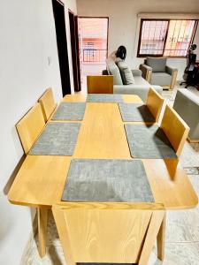 a wooden table with chairs and a living room at Apto familiar 2 hab WiFi rápido y balcón in Sabaneta