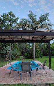 a patio with a table and chairs and a pool at Quinta con pileta y quincho in Fátima