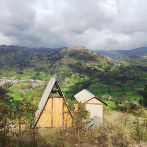 a small house sitting on top of a hill at Hostal ML las tres B in El Cocuy