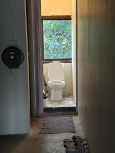 een badkamer met een toilet en een raam bij Sunnies 24 in Phra Ae beach +27 foto's