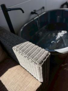 a bathroom sink with a wicker basket next to it at MIRATIO Sauna Onna in Onna +62 photos