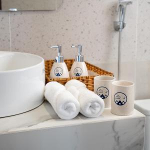 een stapel handdoeken en kopjes op een plank in een badkamer bij The Moon's House in Mộc Châu +73 foto's