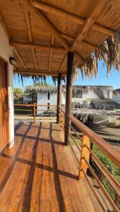 a wooden deck with a roof with a view of the ocean at Casa Arena y Mar in Los Órganos