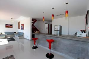a kitchen and living room with red stools at Casa Arena y Mar in Los Órganos