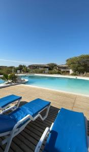 a resort with a swimming pool and two blue lounge chairs at Casa Arena y Mar in Los Órganos
