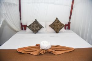uma cama com uma toalha e um chapéu em The Golden Sand Villa in Unawatuna em Unawatuna mais 45 fotografias