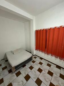 een kamer met een bed en een rood gordijn bij Pousada Ícone dos Mares in Mongaguá