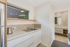 una cocina con fregadero y ventana en Sirocco on Main, en Merimbula 18 fotos más