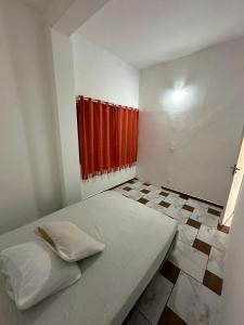 een slaapkamer met een bed en een rood gordijn bij Pousada Ícone dos Mares in Mongaguá