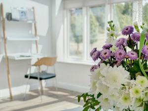 een boeket paarse en witte bloemen in een kamer bij Swallows Nest in Bibury