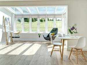 een kamer met een tafel, stoelen en een raam bij Swallows Nest in Bibury