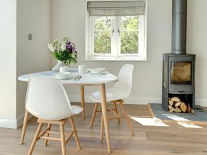 een eetkamer met een tafel en stoelen en een fornuis bij Swallows Nest in Bibury +12 foto's