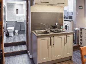 een kleine keuken met een gootsteen en een spoelbak bij Lingmoor View in Ambleside