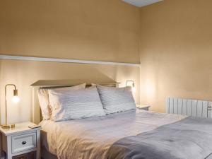 een slaapkamer met een bed met witte lakens en kussens bij Lingmoor View in Ambleside