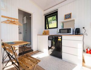 een kleine keuken met een tafel en een magnetron bij Stour Cabin by Tiny Away in Huiroa