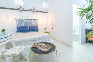 a bedroom with a bed and a table and a chair at Casa Azul Tropical House by Xarm Apartments in Santa Marta +37 photos