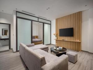 a living room with a couch and a tv at Minerva Aparthotel Hanoi in Hanoi