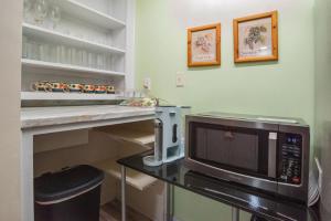 een keuken met een magnetron op een tafel bij Mariposa Coral Home for 4 in Kerrville