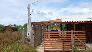 a wooden building with a gate and a fence at Los Sosa y Más in Santa Vitória do Palmar