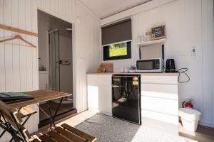 een keuken met een zwarte koelkast en een tafel bij Avon Cabin by Tiny Away in Huiroa