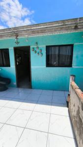 a blue building with a door and a window at Sobrado há 7 quadras da praia in Matinhos