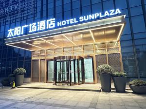 Un hotel con un cartel en lo alto de un edificio. en Suzhou Sun Plaza Hotel, en Suzhou
