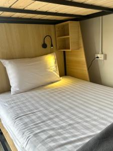 een slaapkamer met een bed met een lamp erop bij Sunnies 24 in Phra Ae beach