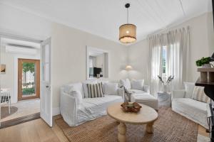 un salon avec des meubles blancs et une table dans l'établissement 4 Dawson St Goolwa - Linen Included, à Goolwa