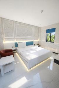 Un dormitorio con una gran cama blanca y una silla. en 168 Hotel, en Ho Chi Minh 52 fotos más