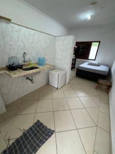 une pièce avec un lavabo et un lit dedans dans l'établissement Pousada Preziosa Beach Itanhaém, à Itanhaém