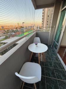 balcone con tavolo bianco e 2 sedie di Bann-Kun Impact Muang Thong 2BR Condo Wi-Fi MRT Pink Near Airport DM 