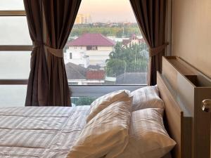 un letto in una camera da letto con una grande finestra di Bann-Kun Impact Muang Thong 2BR Condo Wi-Fi MRT Pink Near Airport DM 