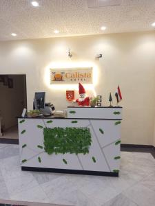 een kantoor met een balie waarop groene planten staan bij Calista Hotel in Caïro