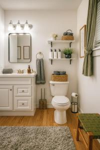 un bagno con un water, un lavandino e uno specchio di The Lagniappe Escape a Marksville