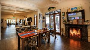 un soggiorno con camino, tavolo e sedie di Maclean Hotel a Maclean