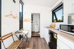 een keuken met een aanrecht en een tafel in een tiny house bij Henge Cabin by Tiny Away in Huiroa +26 foto's