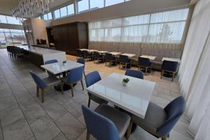 Un comedor con mesas y sillas y ventanas. en Wingate by Wyndham Austin North, en Austin