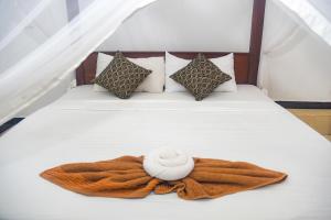 Una cama con una manta y una toalla. en Angel White in Unawatuna, en Unawatuna 45 fotos más