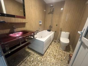 a bathroom with a tub and a sink and a toilet at Hotel Hoàng Lê Tiền Hải in Tiền Hải