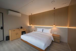 ein Schlafzimmer mit einem großen weißen Bett mit Beleuchtung in der Unterkunft 森山寫照 in Dongshan + 44 Fotos