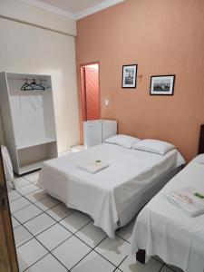 Zimmer mit 2 Betten und einem Kühlschrank in der Unterkunft Pousada Terra do Sol in Caicó