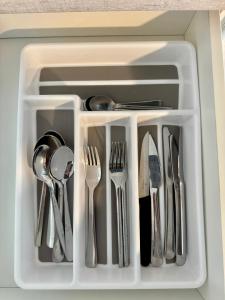 Una bandeja blanca con utensilios en un cajón. en Wanaka Matai Studio, en Wanaka