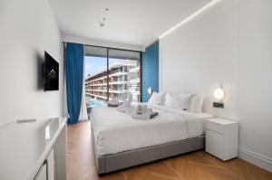 een slaapkamer met een groot bed en een groot raam bij Premier Kora 3-Bedroom Apartment E333 Beachfront in Layan Beach +33 foto's