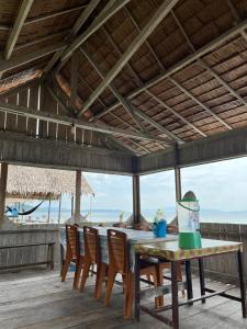 a dining table with chairs and a view of the beach at Korbekwan Homestay in Besir