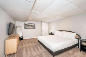 a bedroom with a large white bed and a television at The Terrace Timber House For 8 in Hamilton