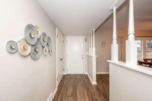 a hallway with white walls and a staircase with plates on the wall at The Terrace Timber House For 8 in Hamilton +39 photos