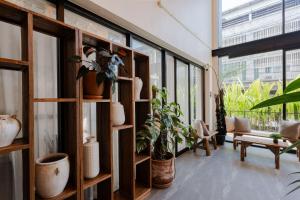 a room with shelves with potted plants and windows at The Tribe Nimman Boutique Hotel in Chiang Mai