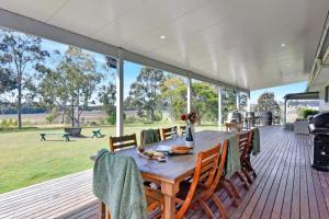 a wooden table and chairs on a deck at Glandore Estate in Pokolbin