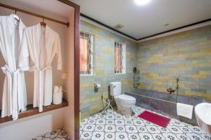 a bathroom with a tub and a toilet and a sink at SATTA Private Pool Grill & Chill Villa in Siem Reap