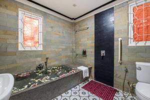 a bathroom with a bath tub with flowers on the floor at SATTA Private Pool Grill & Chill Villa in Siem Reap +77 photos